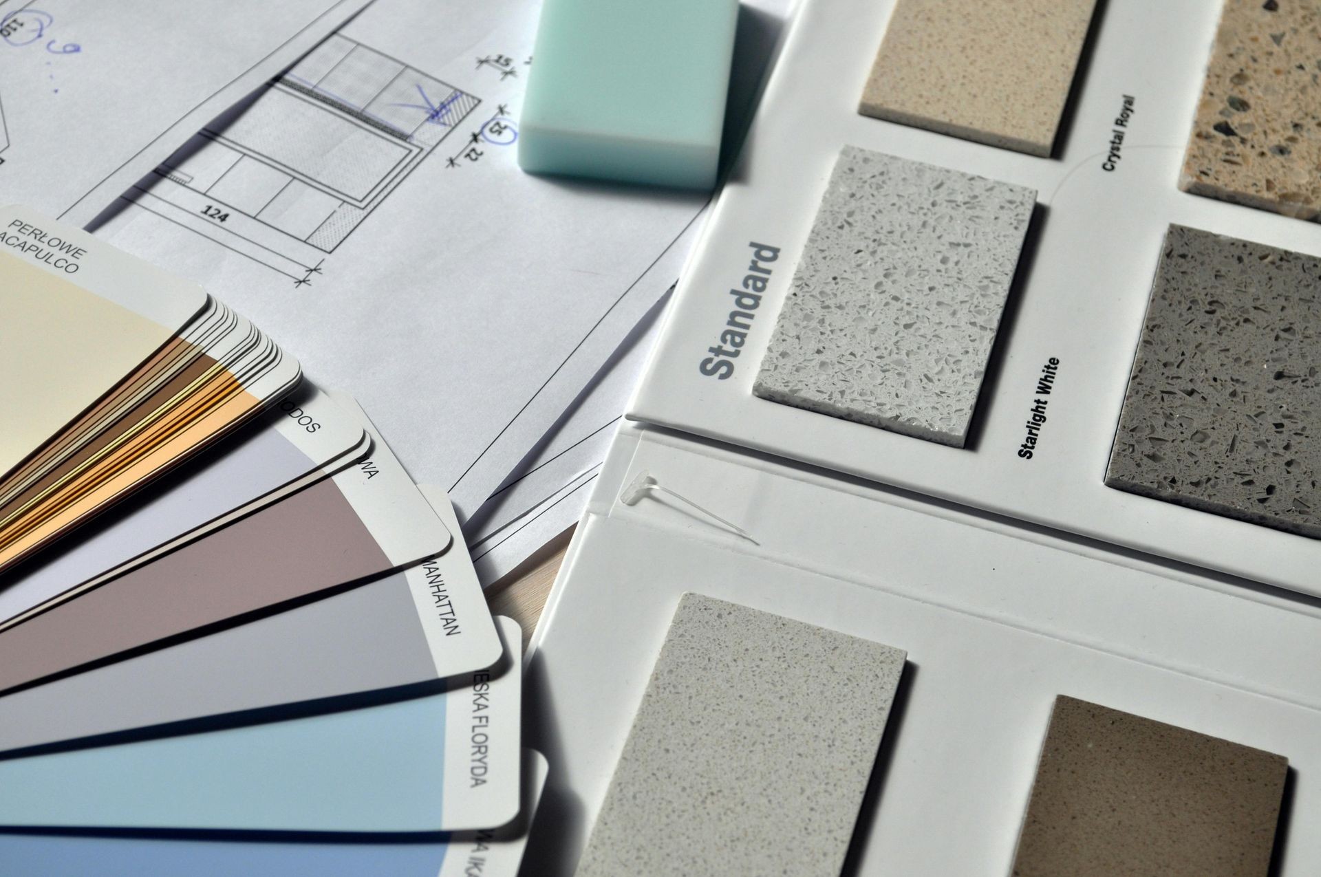 Close-up of architectural plans, color swatches, and material samples for interior design.